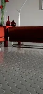 Low angle view of a modern living room featuring a textured silver floor and red furniture