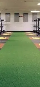 green turf pathway runs down the center of a gym