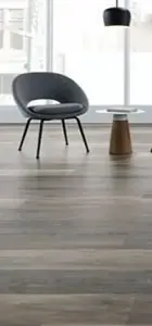 modern gray chair and a small wooden table on light LVT flooring