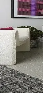 stylish white chair with curved edges sits beside a potted plant